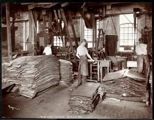 Interiör av tre män som arbetar med läder och tung utrustning på New York Leather Belting Co. i New York, 1905 (silvergelatintryck).